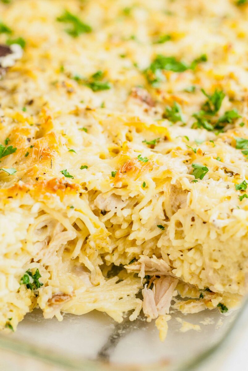 A slice of turkey tetrazzini has been removed from a baking dish.