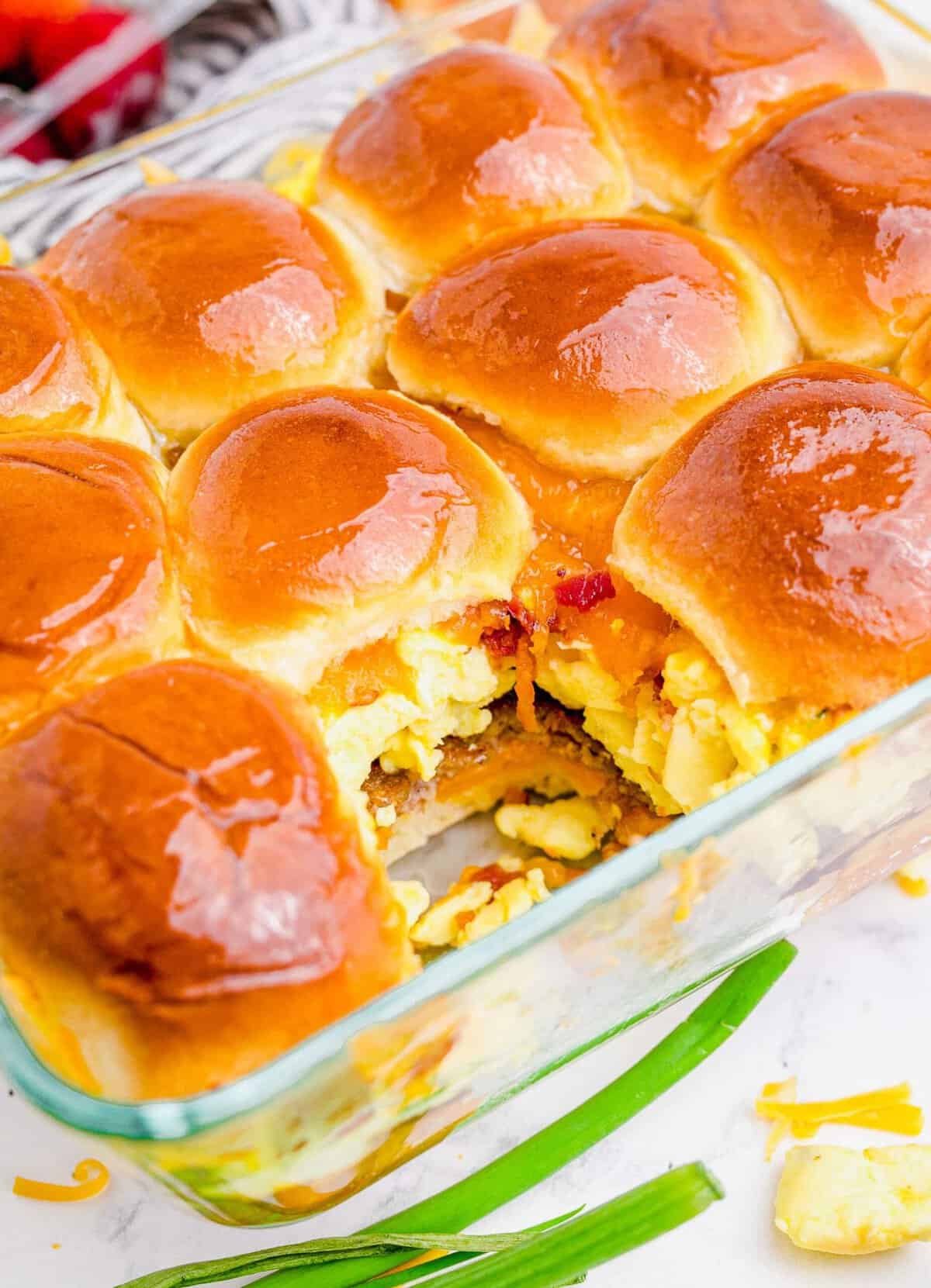 Breakfast sliders in glass baking dish with one removed