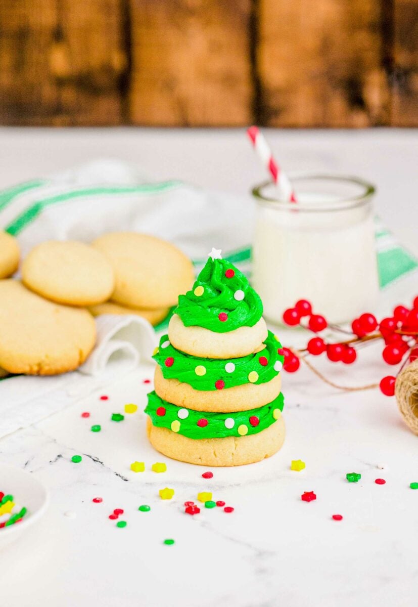 A Christmas tree cookie is presented on white marble countertop. 