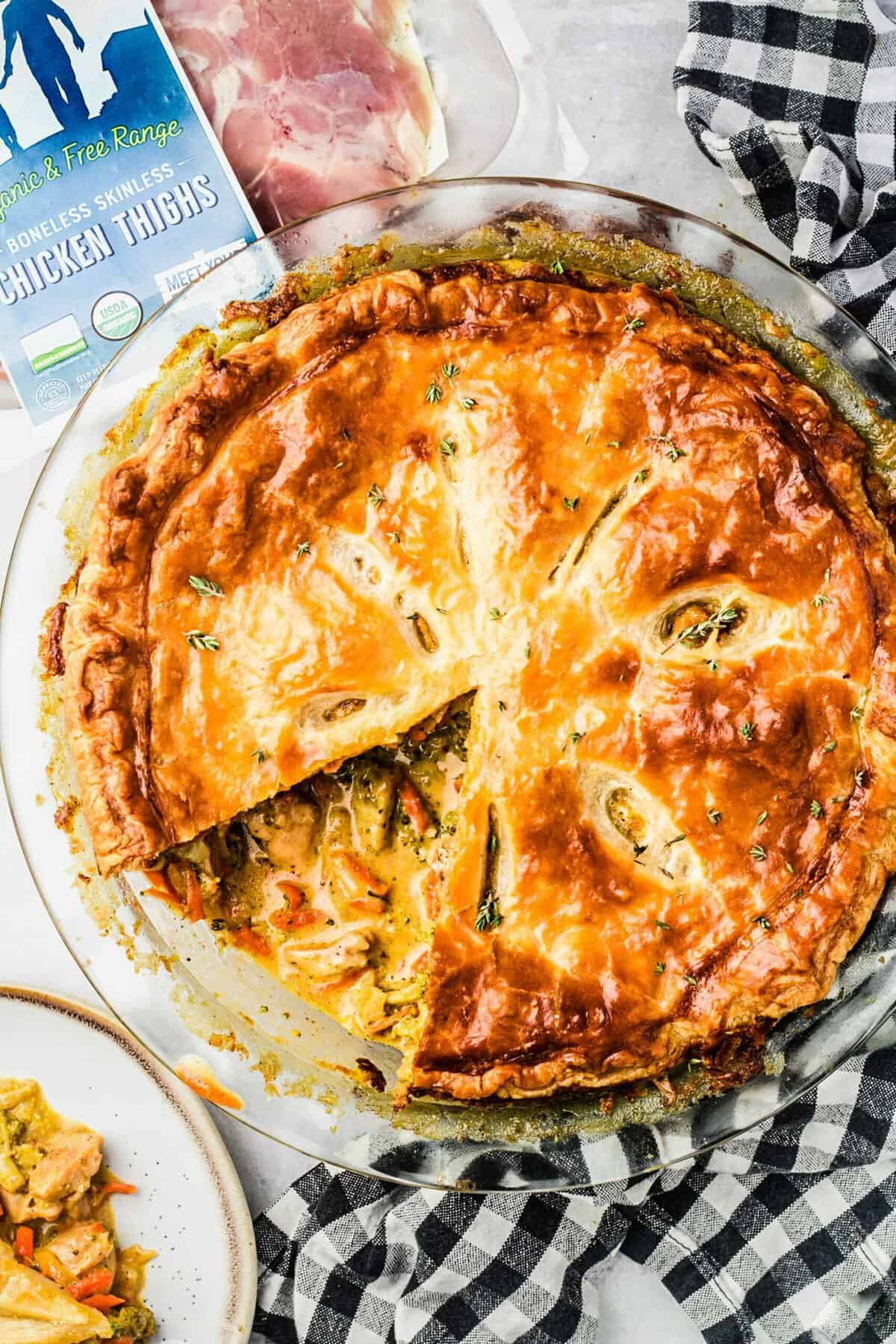 Overhead view of cheesy broccoli chicken pot pie with one slice removed