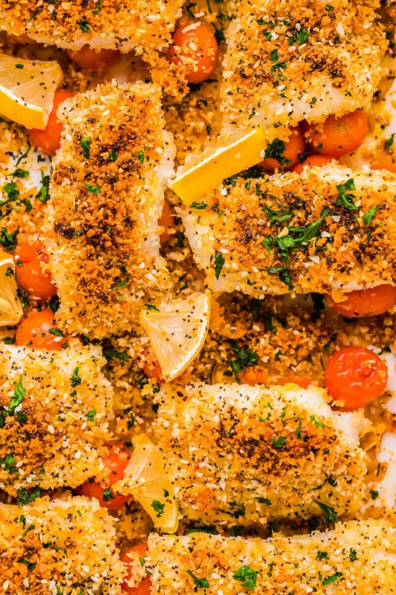 Tomatoes and lemons are spread across the crunchy mixture on the baked cod.