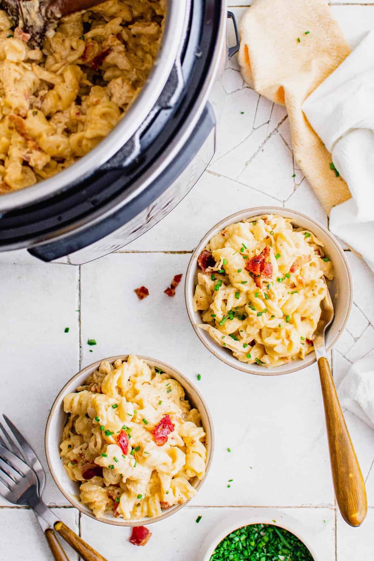 Overhead view of Instant Pot and two bowls filled with chicken pasta