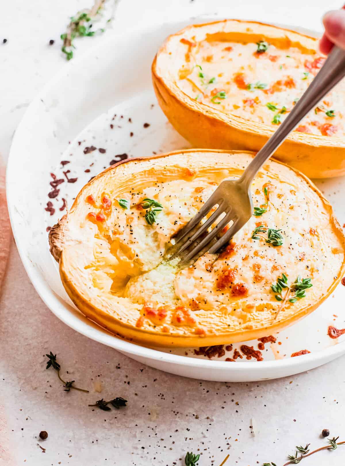 Fork digging into cheesy pesto spaghetti squash boat