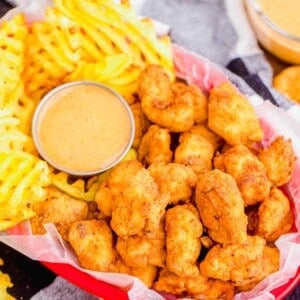 Overhead view of chicken nuggets in basket with waffle fries and dipping sauce