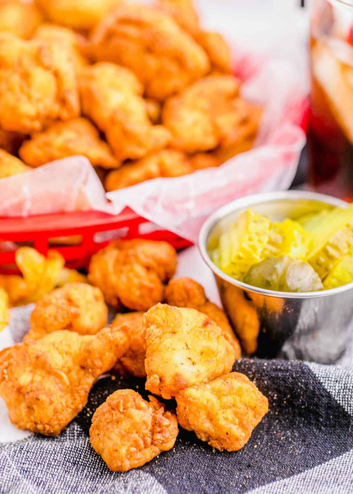 Copycat Chick-Fil-A Chicken Nuggets on napkin with basket of nuggets in background