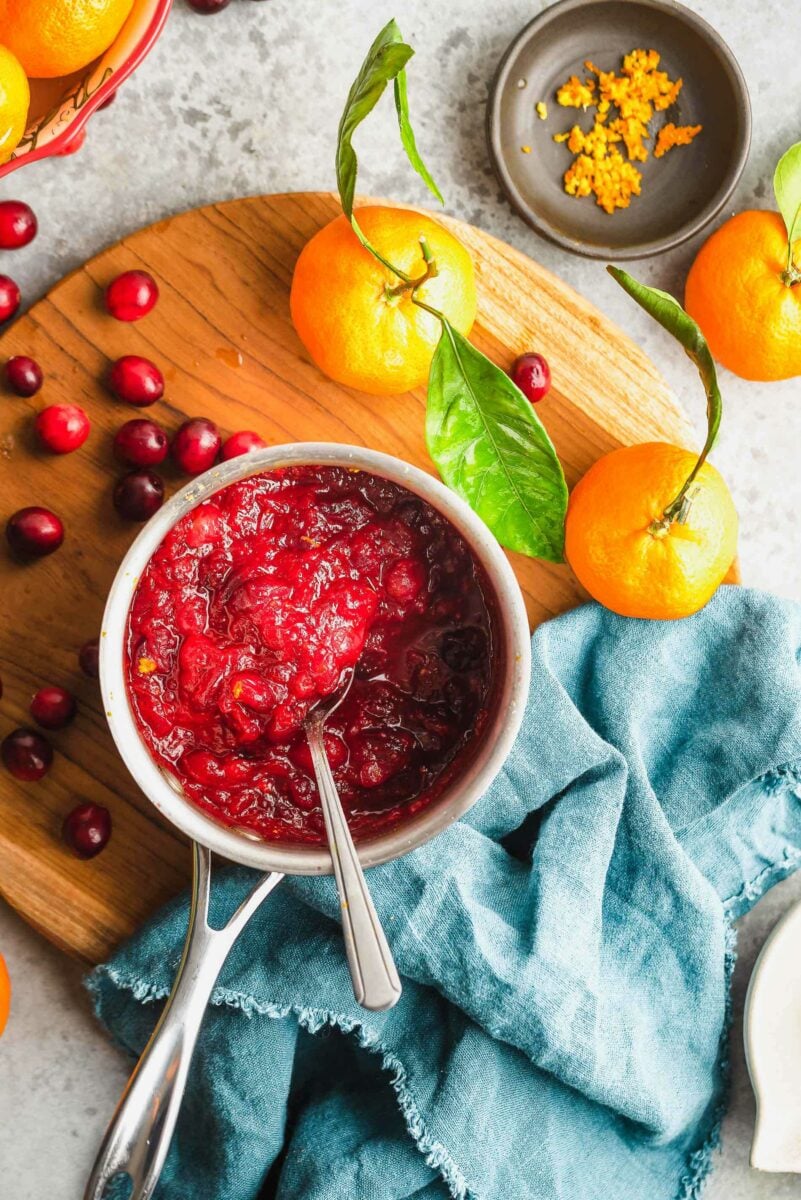 This cranberry orange sauce recipe calls for only 4 ingredients and it takes minutes to make. You'll never go back to the canned stuff again! overhead shot of cranberry orange sauce in saucepan