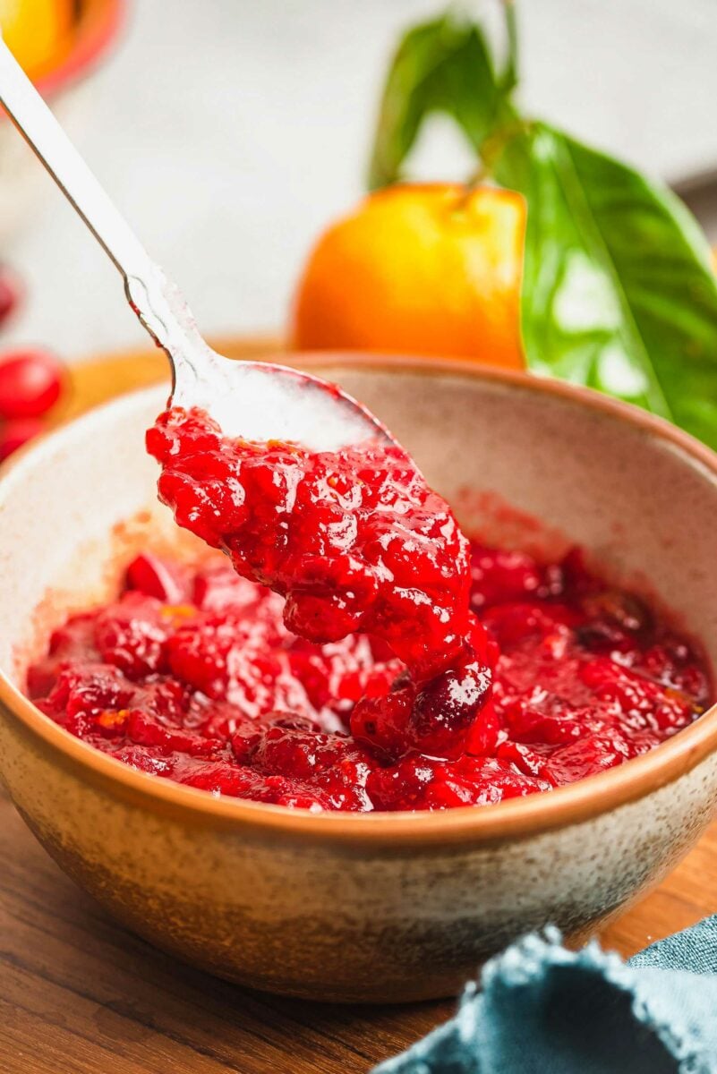 cranberry orange sauce being spooned out of a bowl