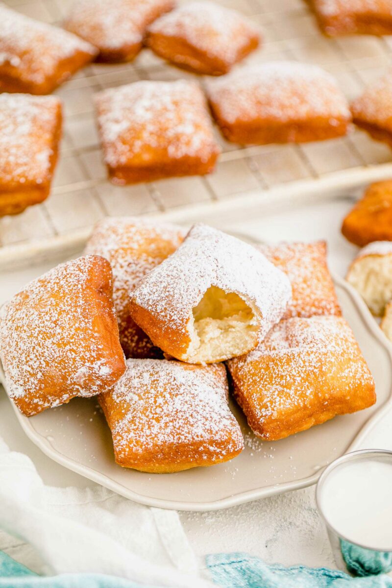 A beignet on top of a pile has been bitten into.