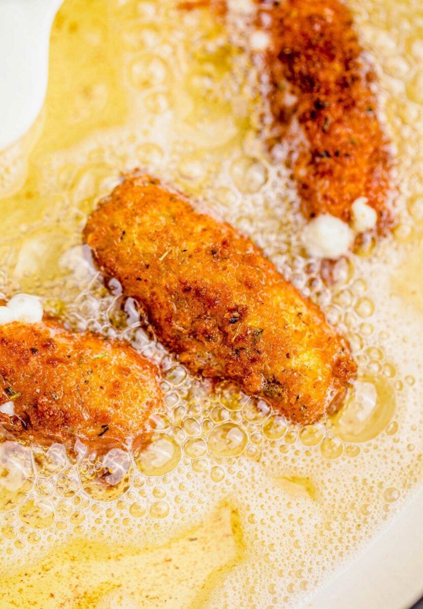 Mozzarella sticks are being fried in oil.