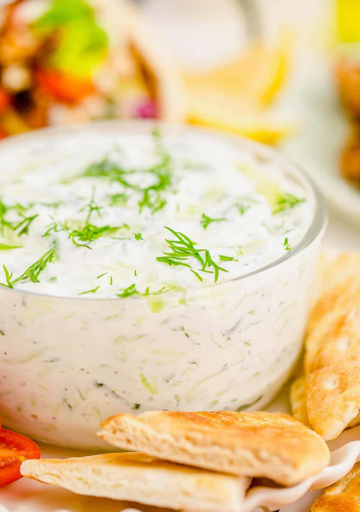 Closeup of tzatziki dip in bowl surrounded by pita chips