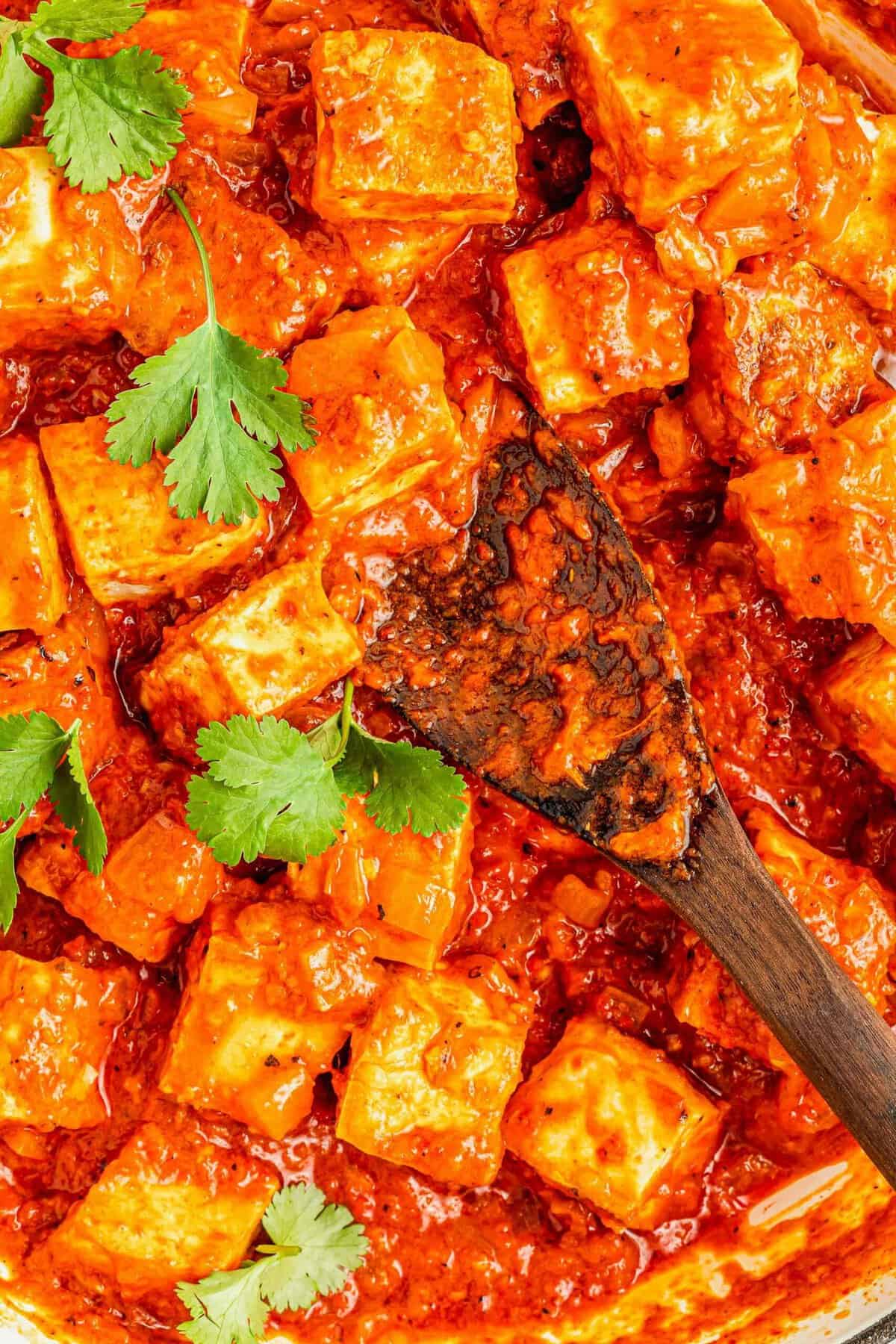Coconut Caribbean Tofu in skillet with wooden spoon