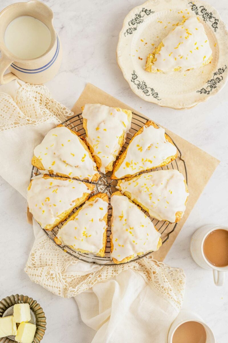 Seven scones are placed in a circle on a wire cooling rack over a square sheet of parchment paper.