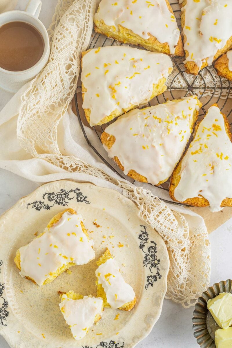 Scones are presented on a cooling rack next to a plated scone. 