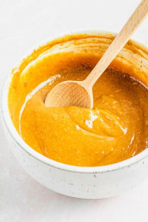A bowl of peanut dipping sauce with a spoon.