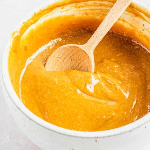 A bowl of peanut dipping sauce with a spoon.