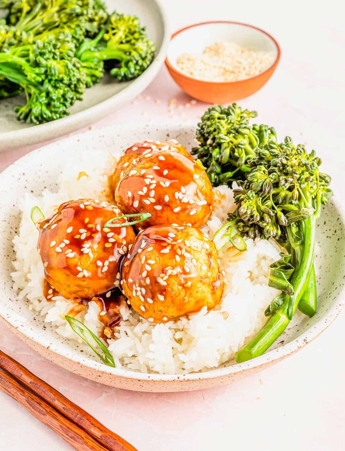 Bowl of rice topped with 3 teriyaki tofu meatballs and spears of steamed broccoli