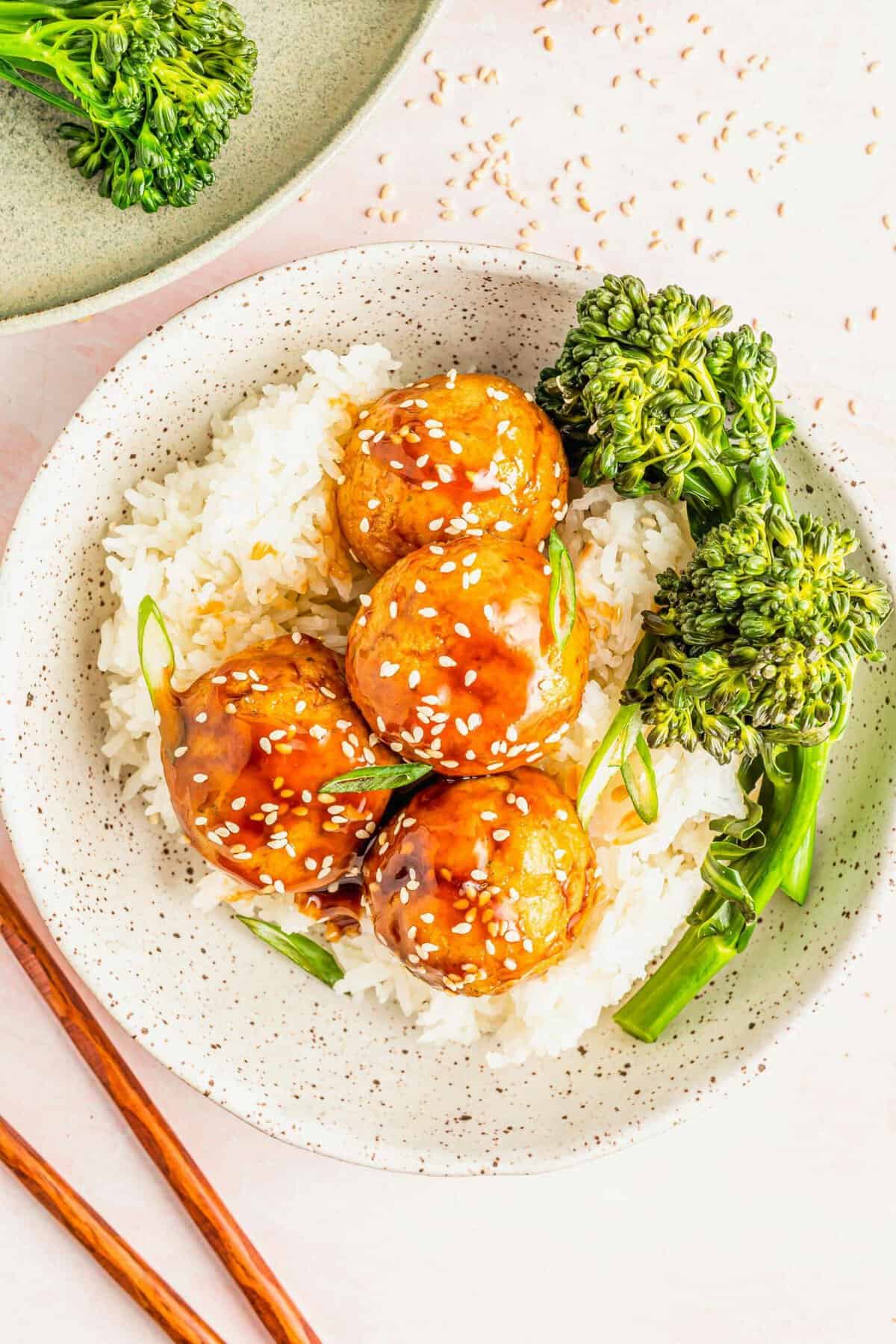 Bowl of rice and steamed broccoli topped with teriyaki tofu meatballs