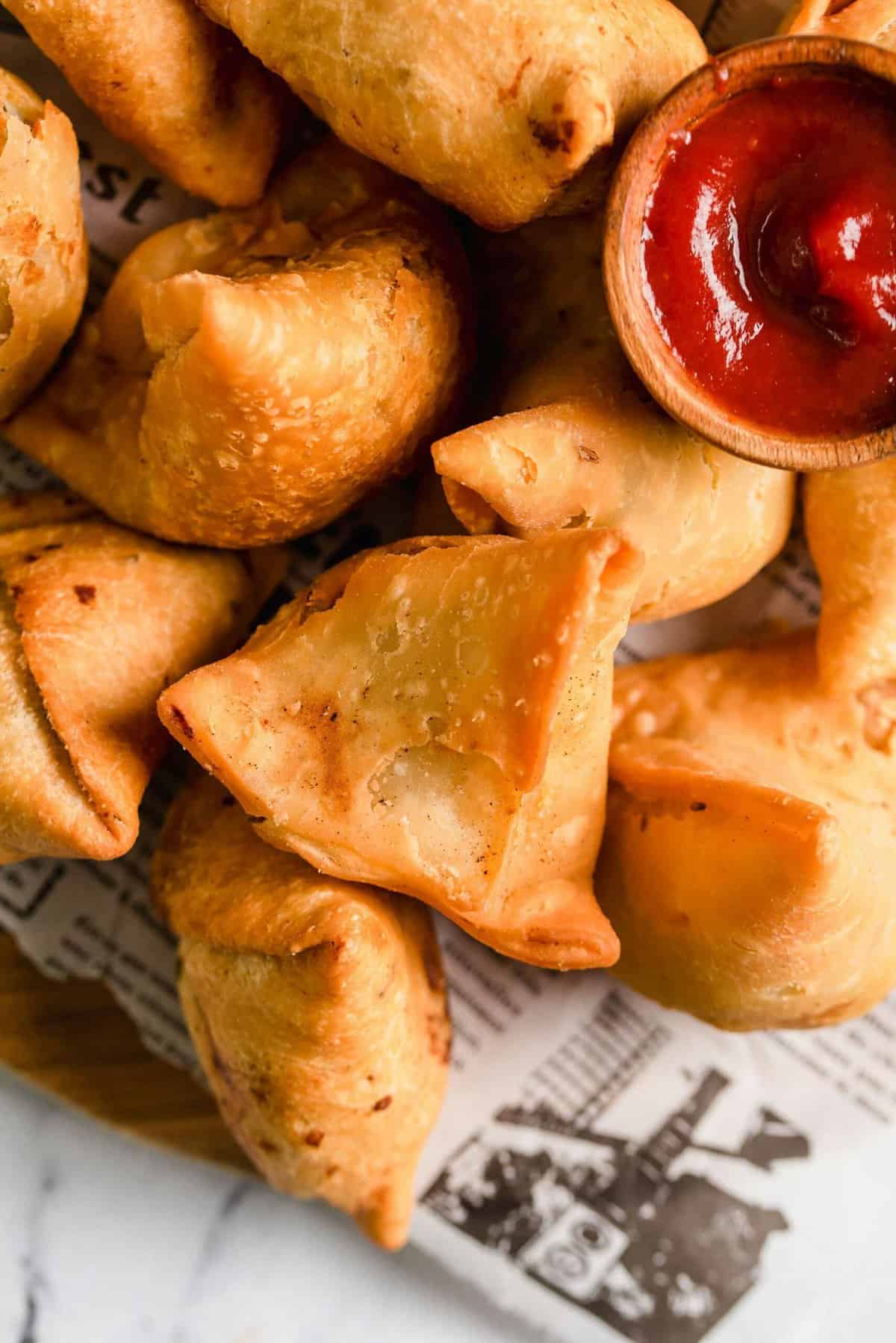 Vegetable samosas with bowl of dipping sauce