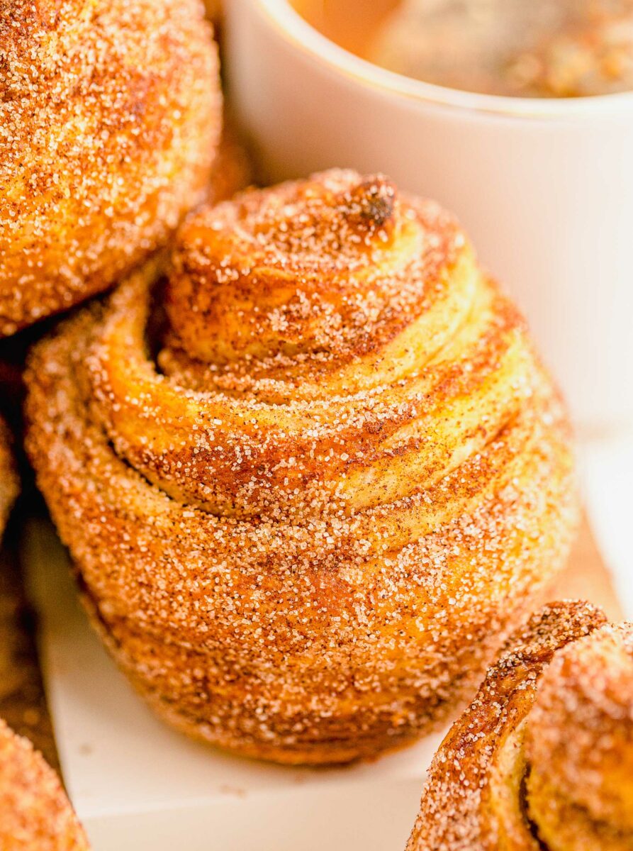 A close up of a cronut shows that it's fully baked and golden brown. 