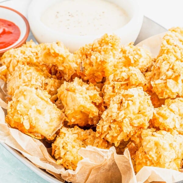 Basket of popcorn tofu with 2 bowls of dipping sauce