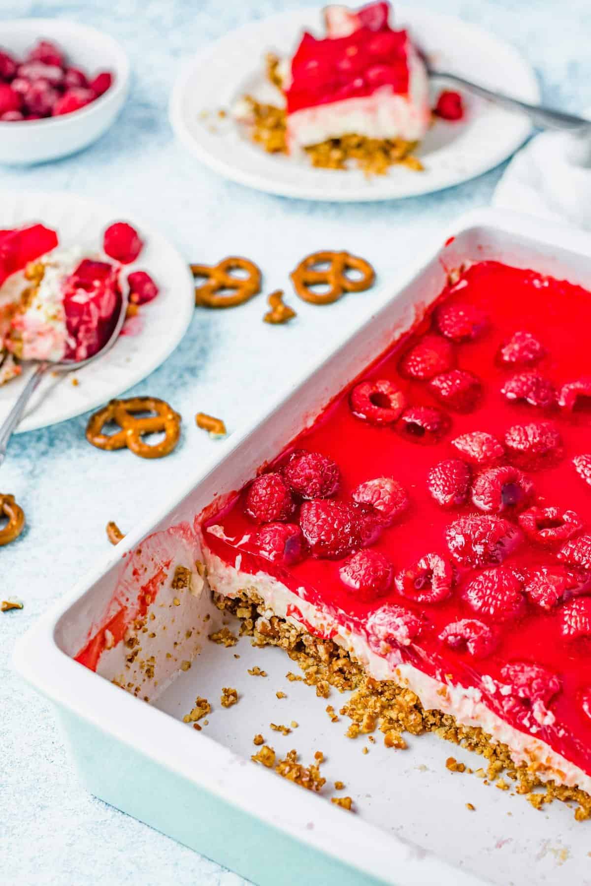 Raspberry pretzel salad in dish with two slices on plates