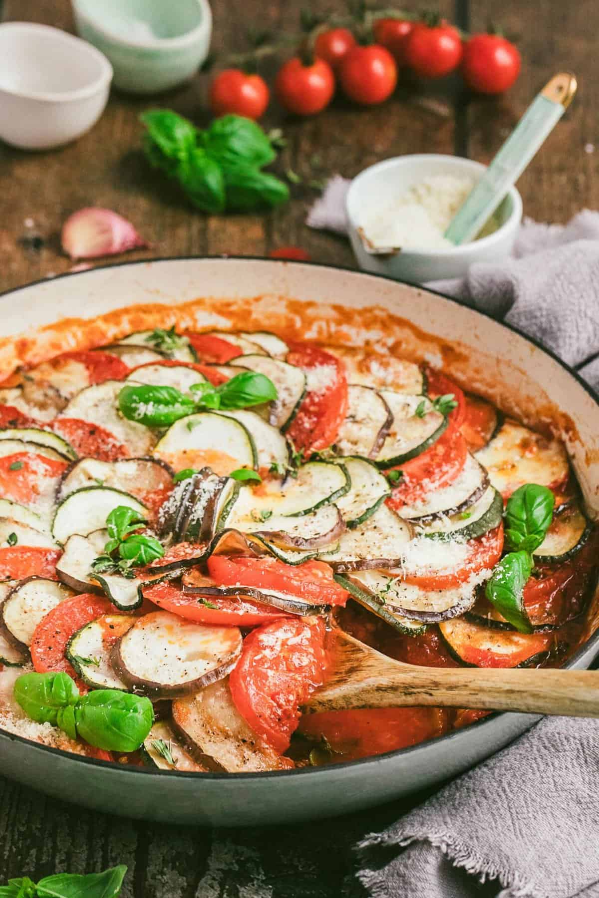 Ratatouille in round baking dish with wooden spoon