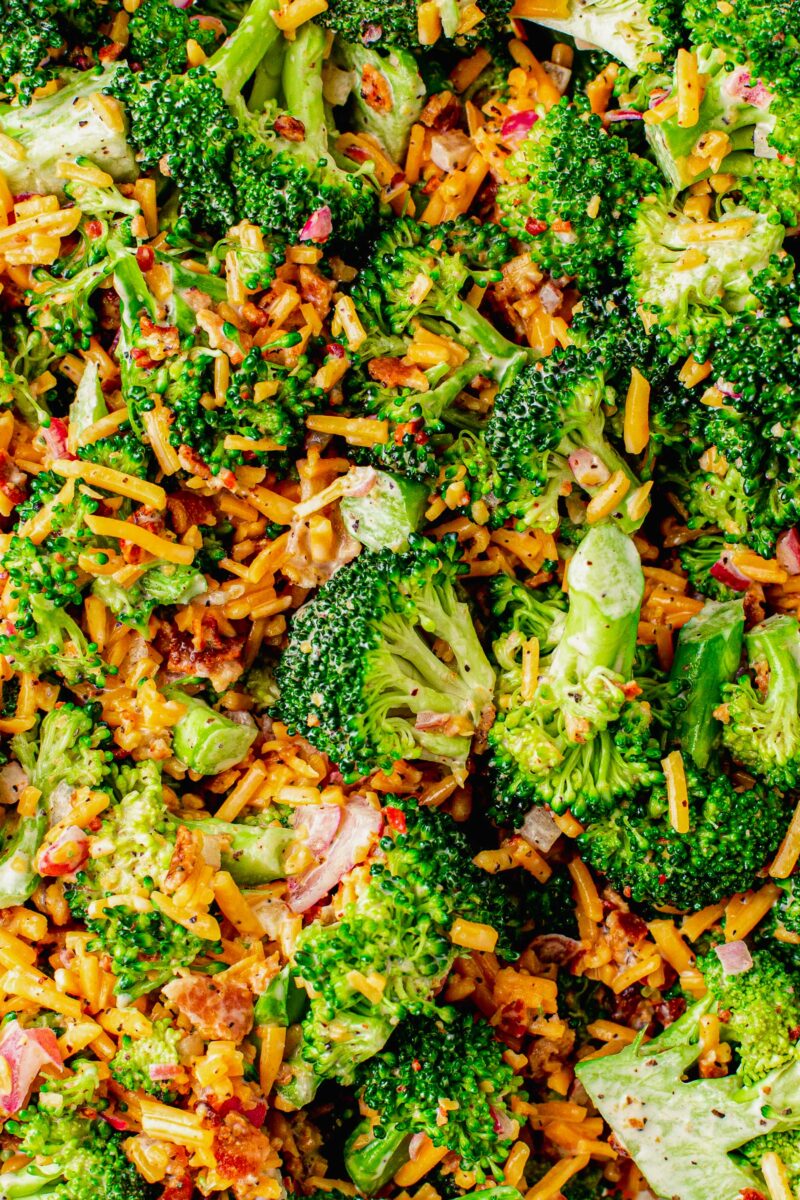 Broccoli, cheese, bacon, and chopped red onions are all tossed together. 
