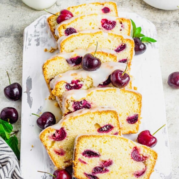 Sliced cherry amaretto loaf cake on rustic cutting board