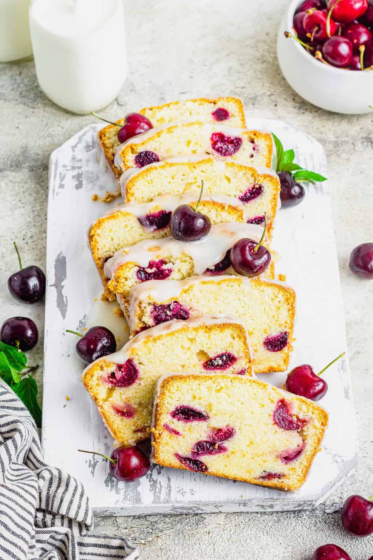 Sliced cherry amaretto loaf cake on rustic cutting board