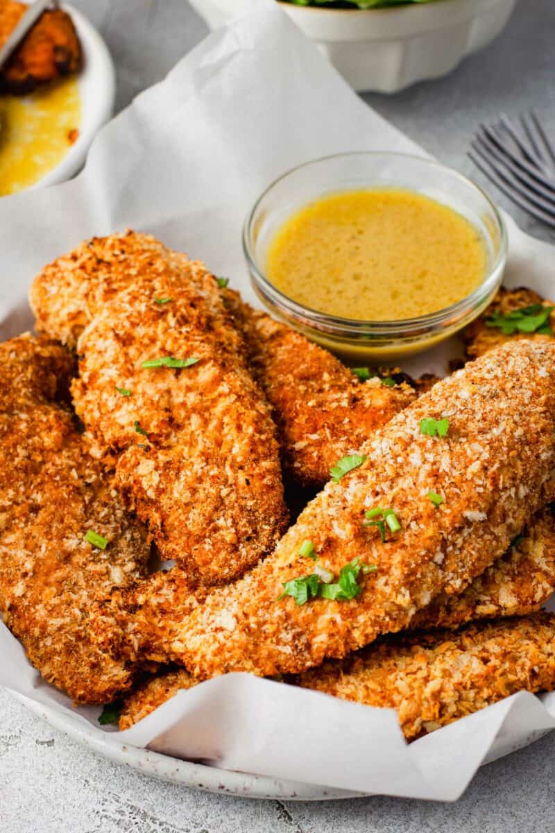 Chicken tenders are garnished with fresh herbs. 