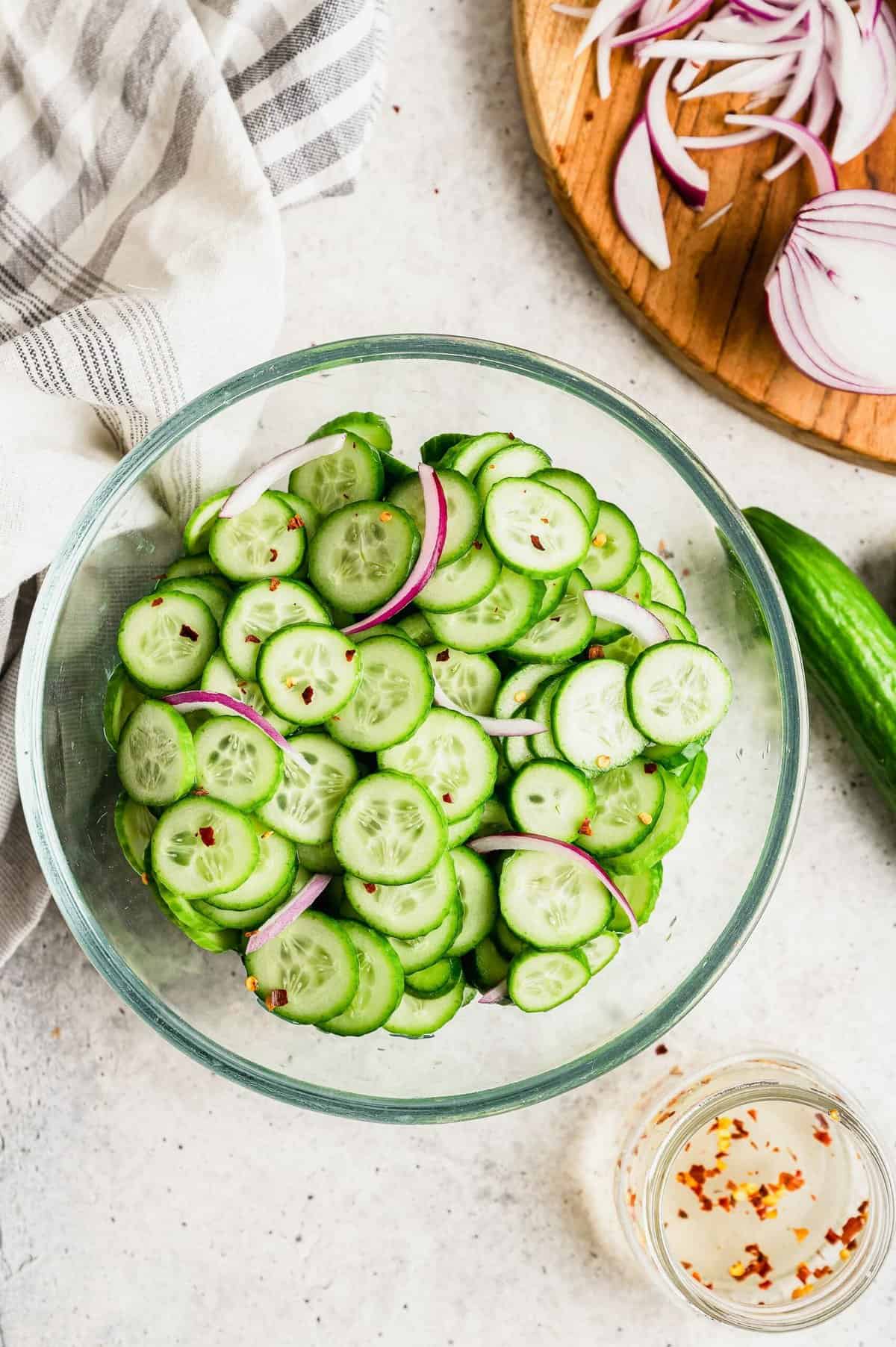 Overhead view of cucumber salad in glass bowl