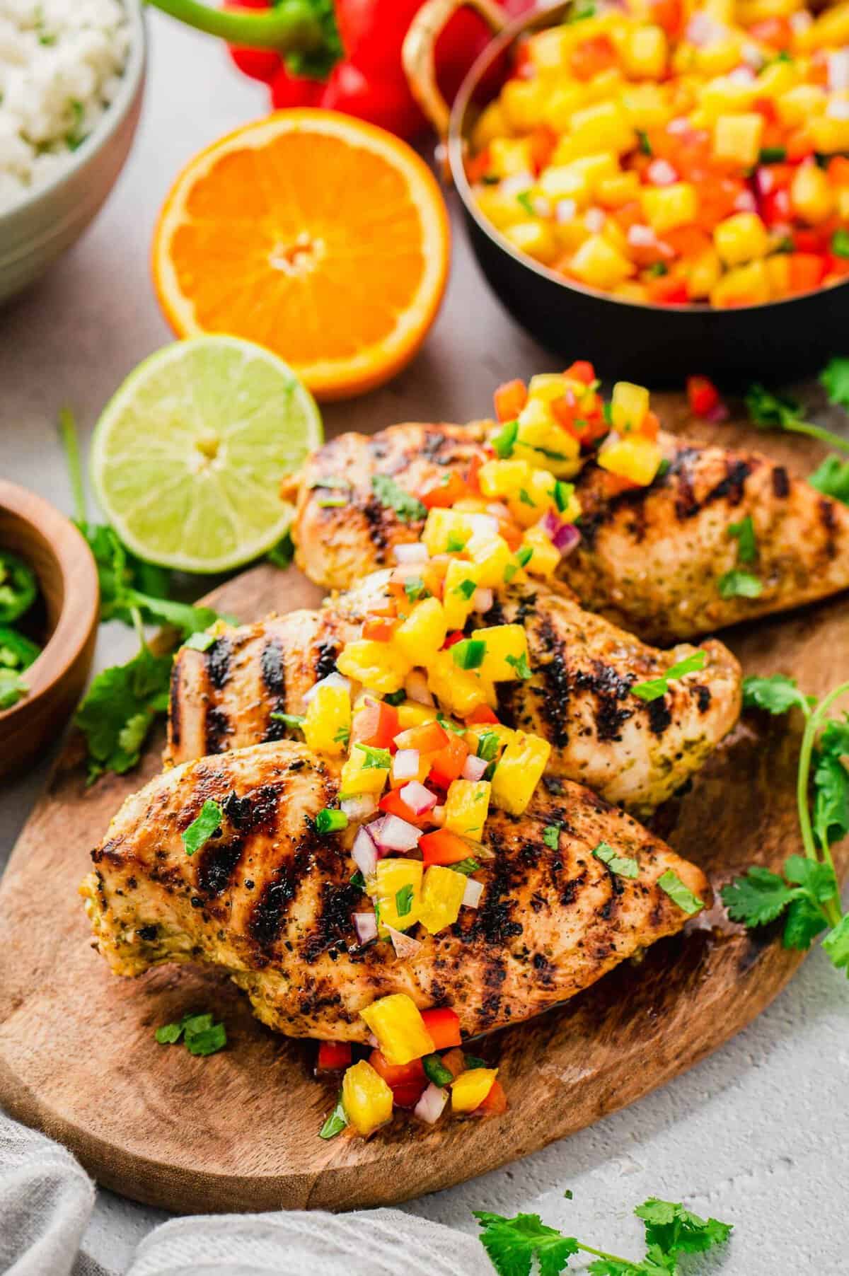 Three grilled chicken breasts topped with pineapple salsa