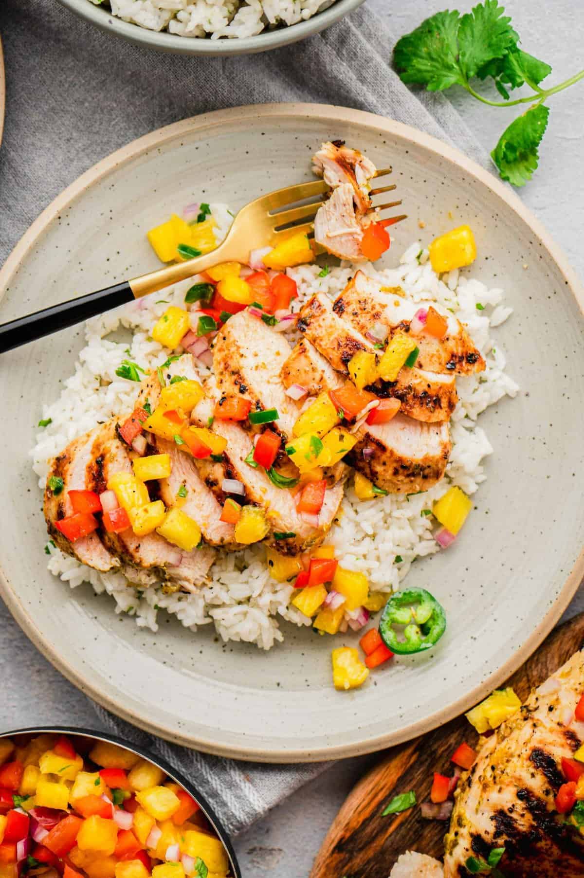 Overhead view of grilled mojo chicken on plate with rice and pineapple salsa