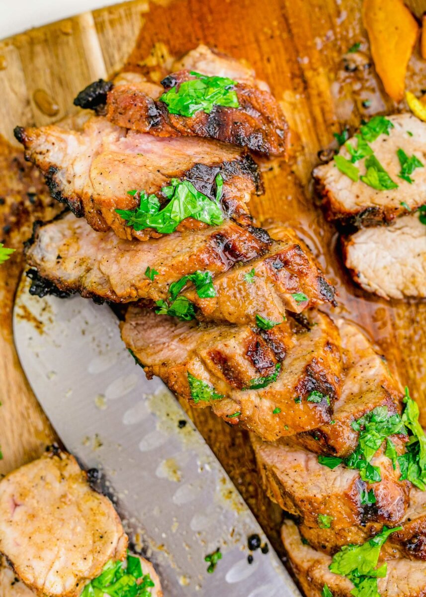 Fresh herbs garnish slices of grilled pork tenderloin. 