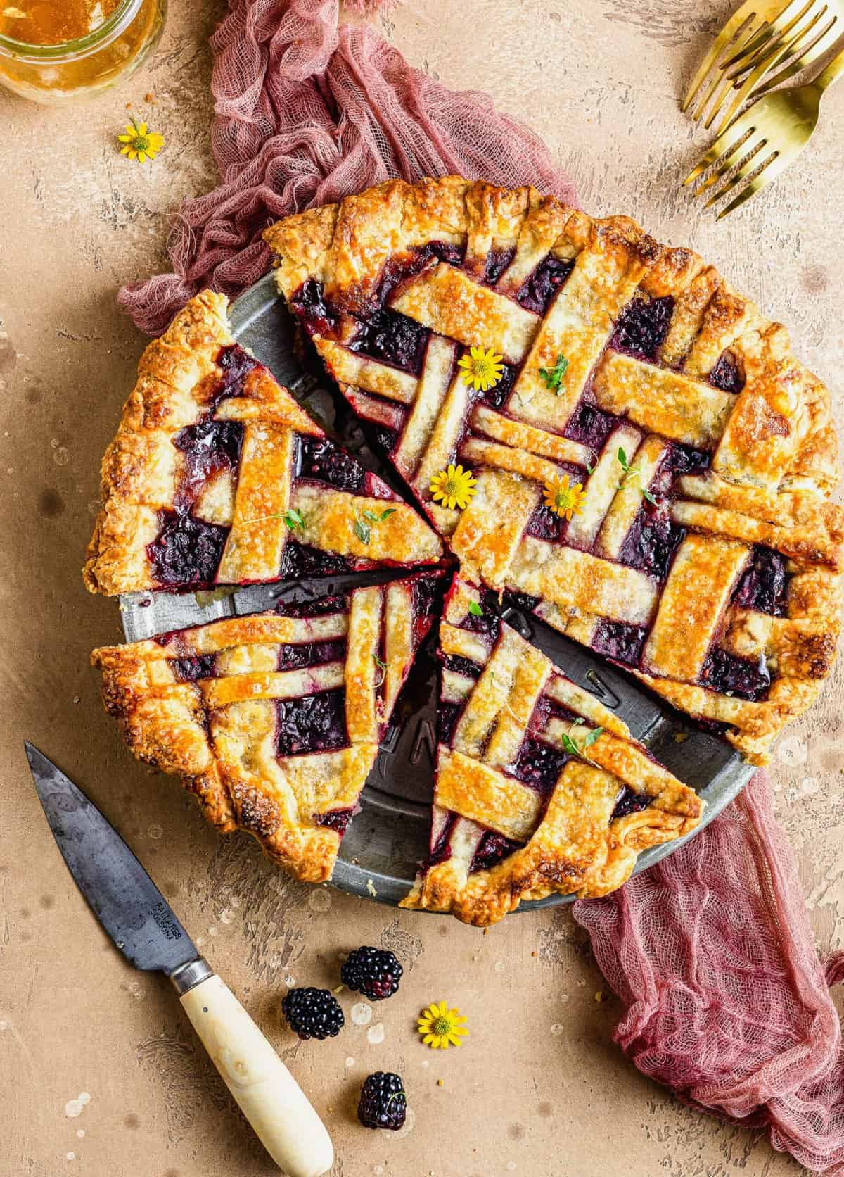 Overhead view of honey thyme blackberry pie cut in pie plate