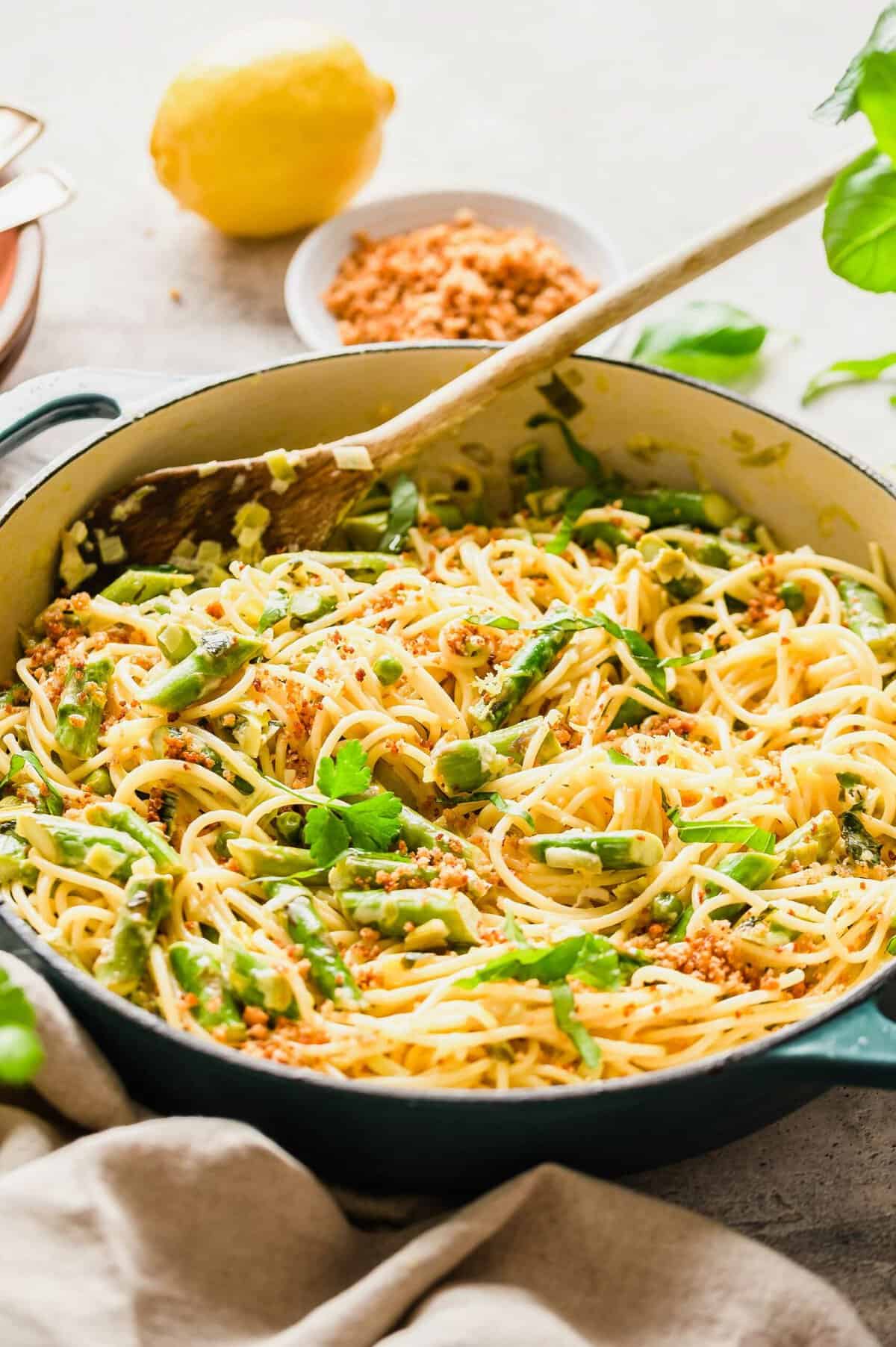 Asparagus and lemon pasta in skillet with wooden spoon