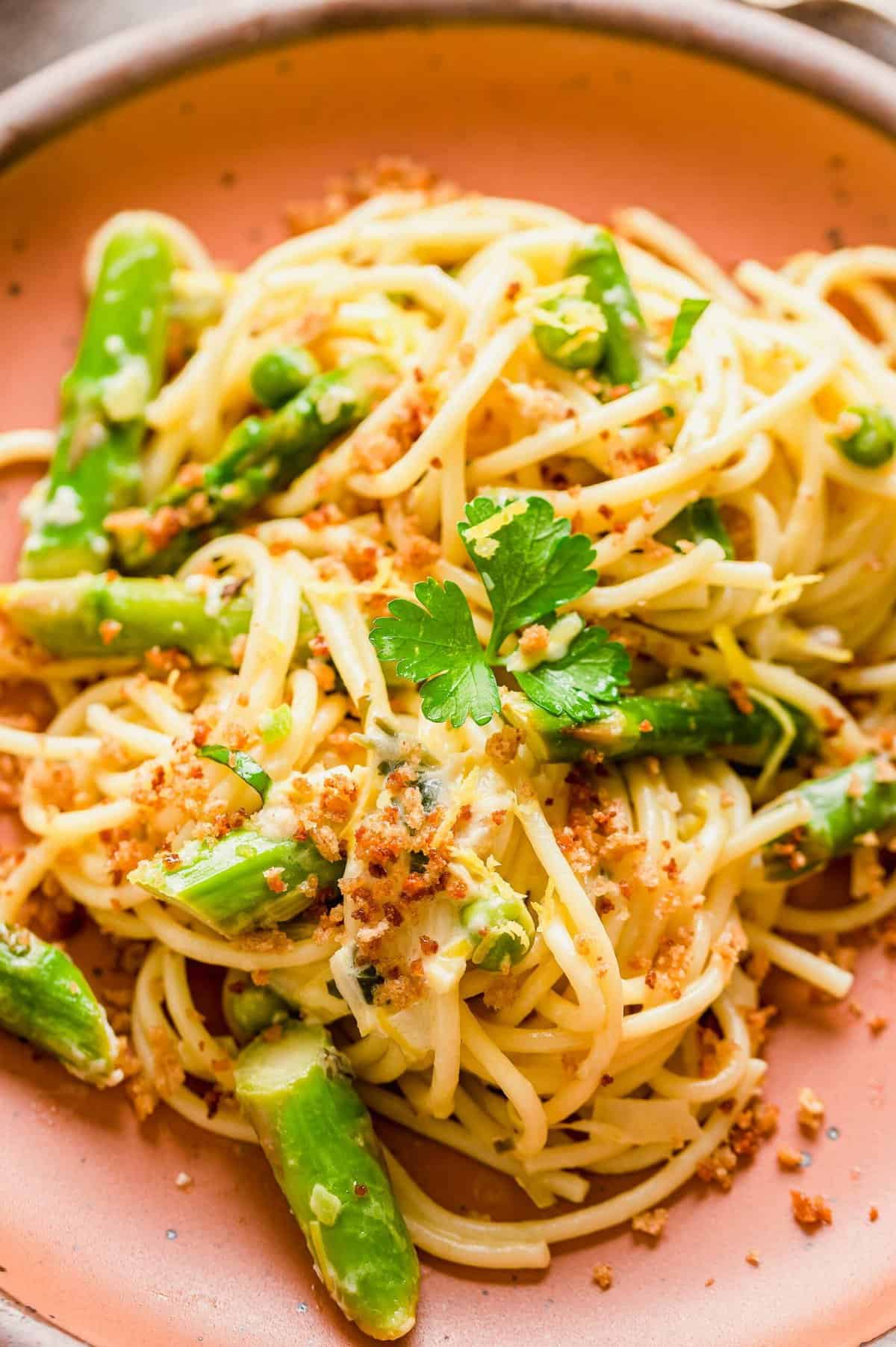 Asparagus and lemon pasta on plate garnished with herbs and breadcrumbs