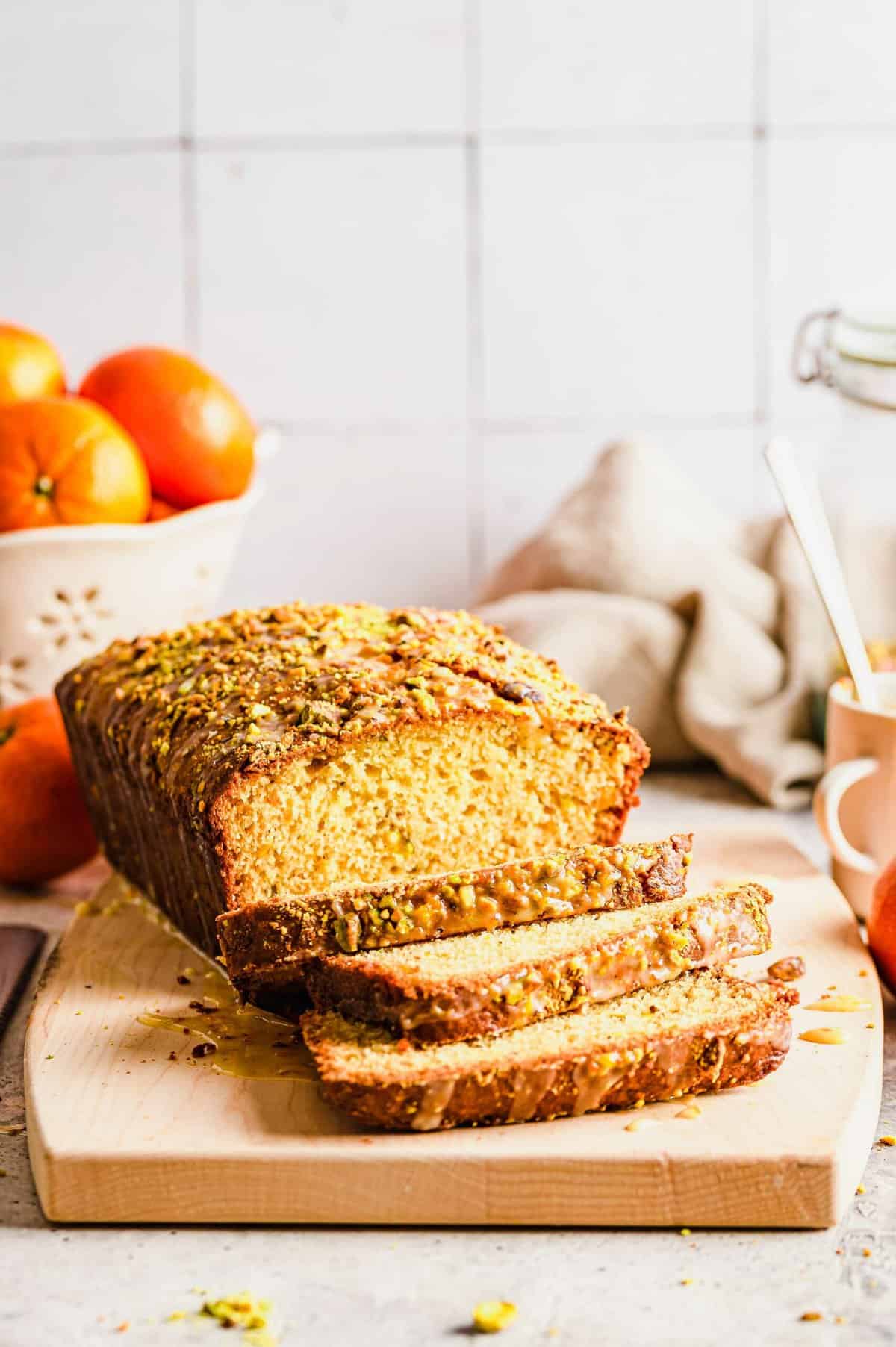 Sliced orange pistachio bread on cutting board