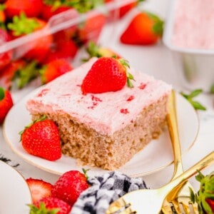 Strawberry sheet cake square on plate, garnished with fresh strawberries