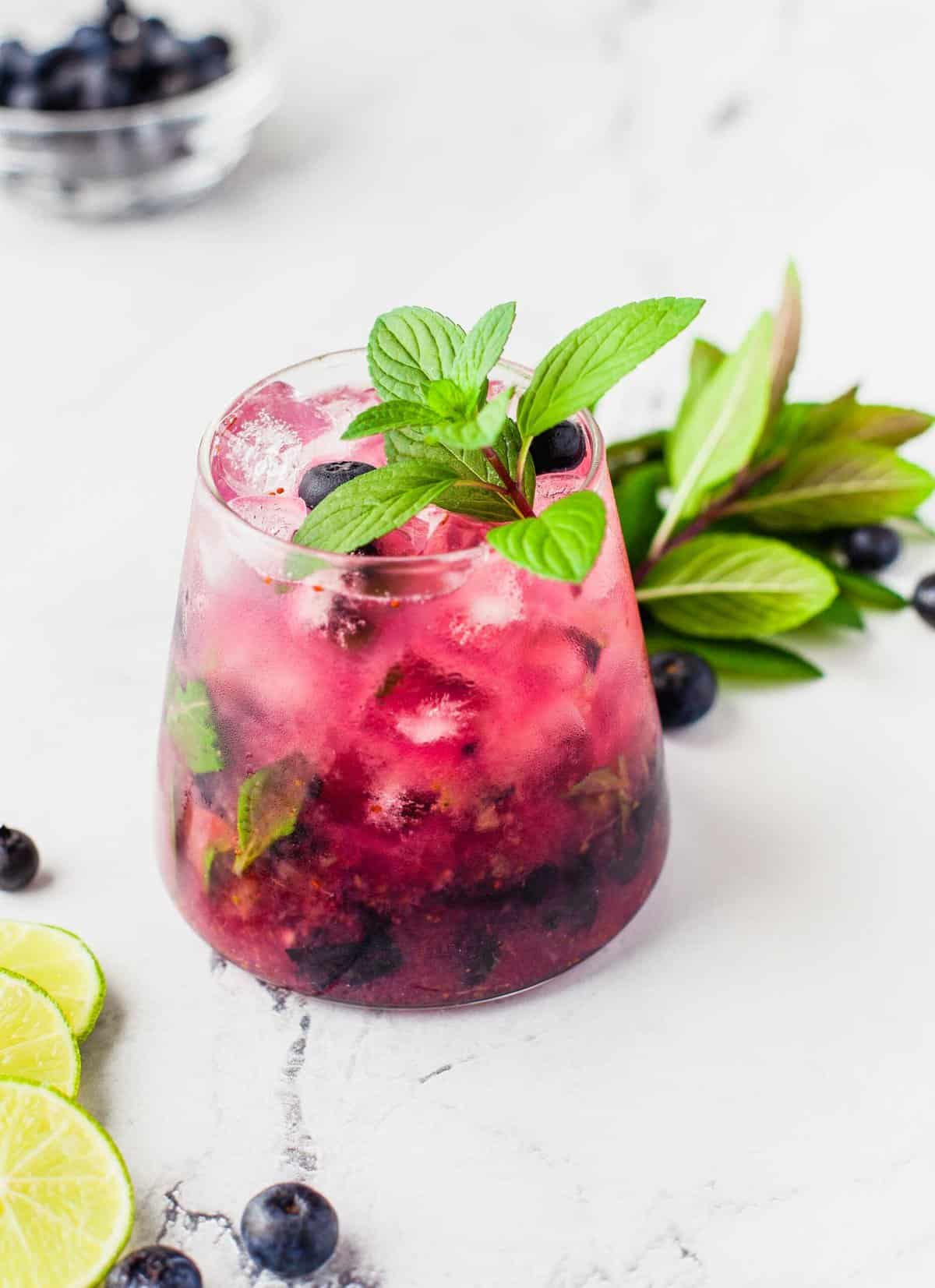 Blueberry mojito garnished with a sprig of fresh mint