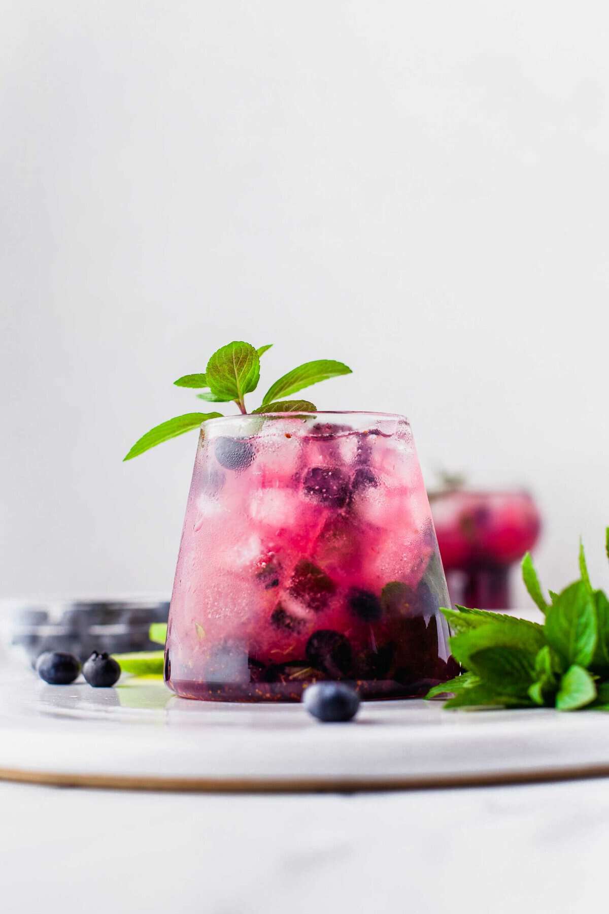 Blueberry mojito garnished with sprig of mint leaves