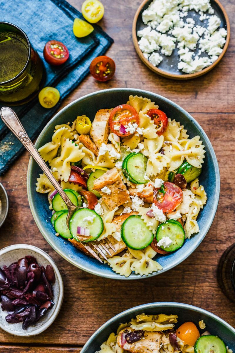 A fork is placed in a bowl filled with pasta salad. 