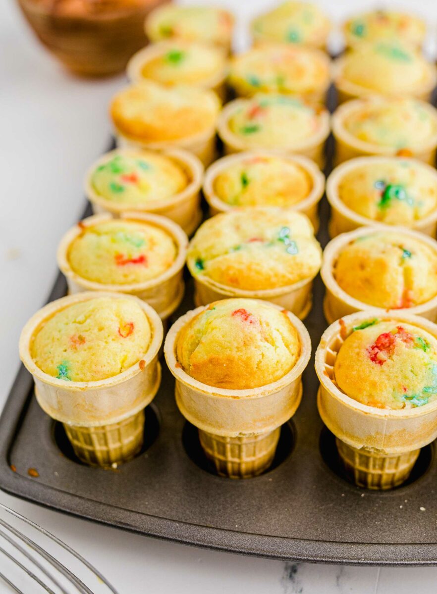 Funfetti cupcakes are baked into ice cream cones and have no additional toppings. 
