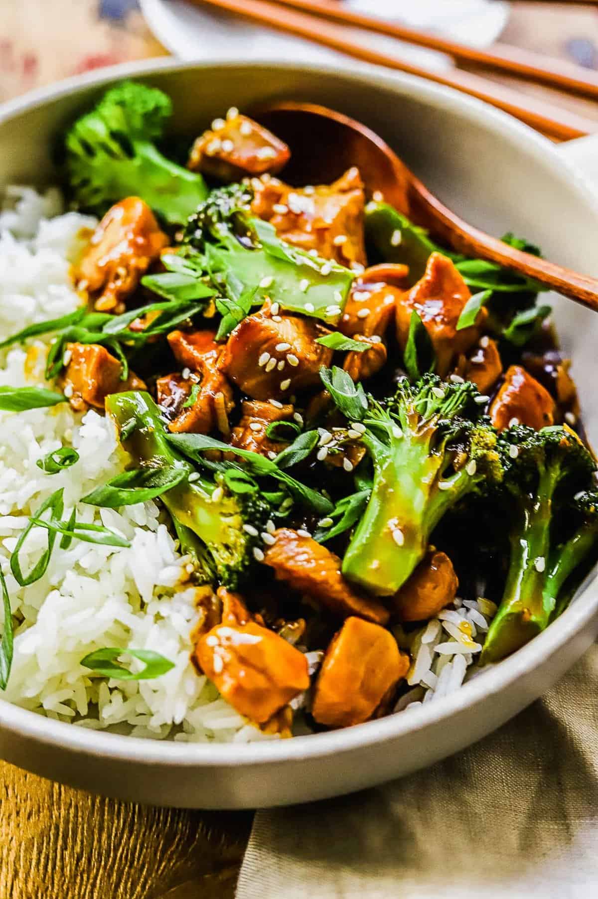 close up of teriyaki chicken and broccoli in a white bowl