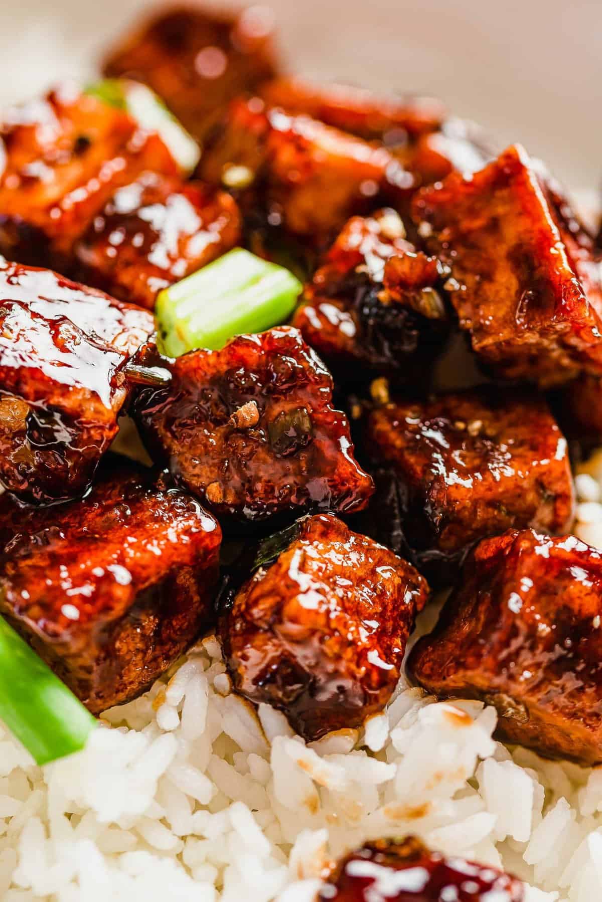 Black pepper tofu is placed on top of a bed of white rice.