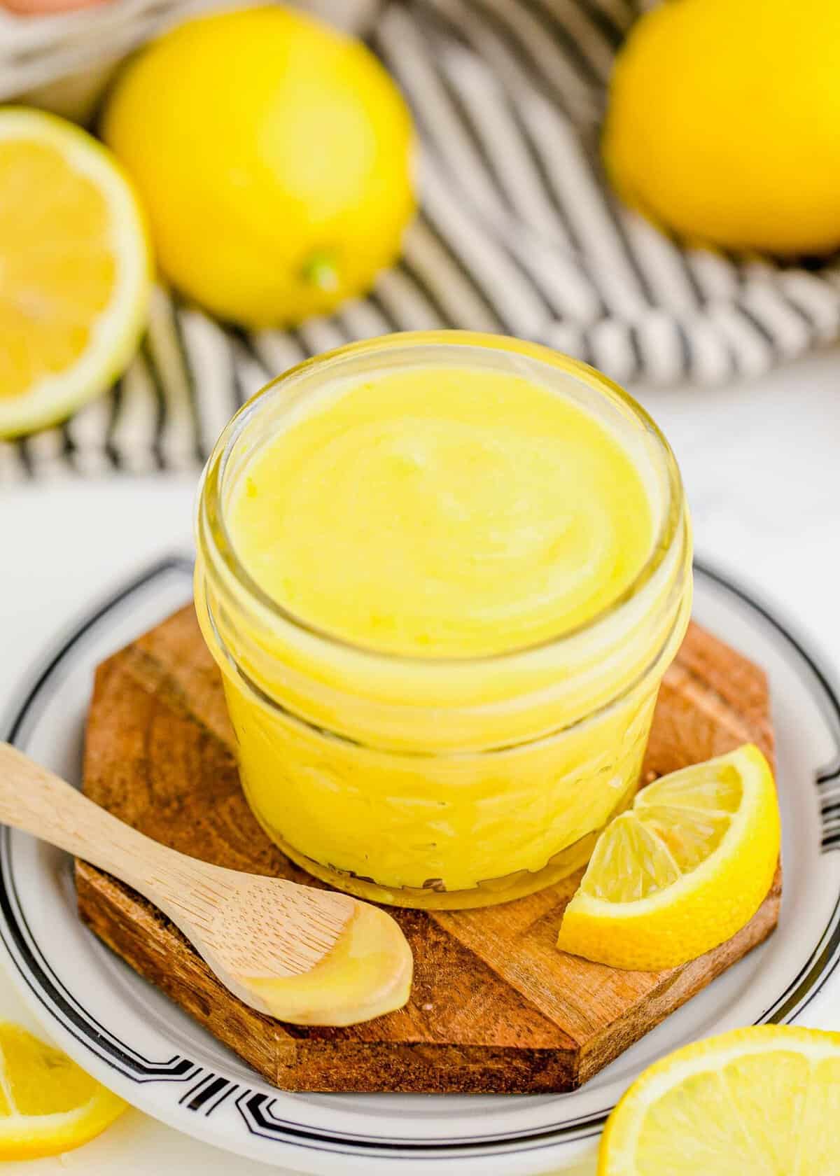 Jar of lemon curd set next to spoonful of curd