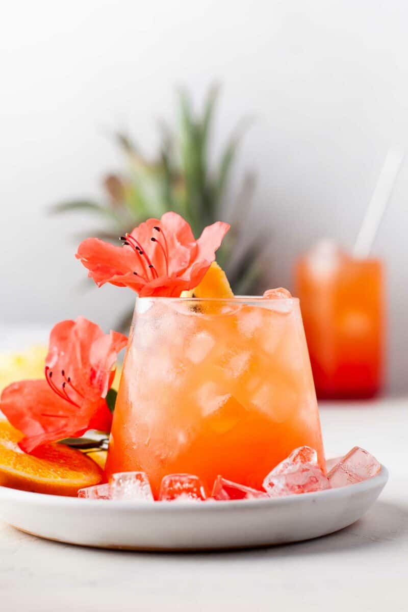 Flowers are placed on top of and around a glass filled with punch. 