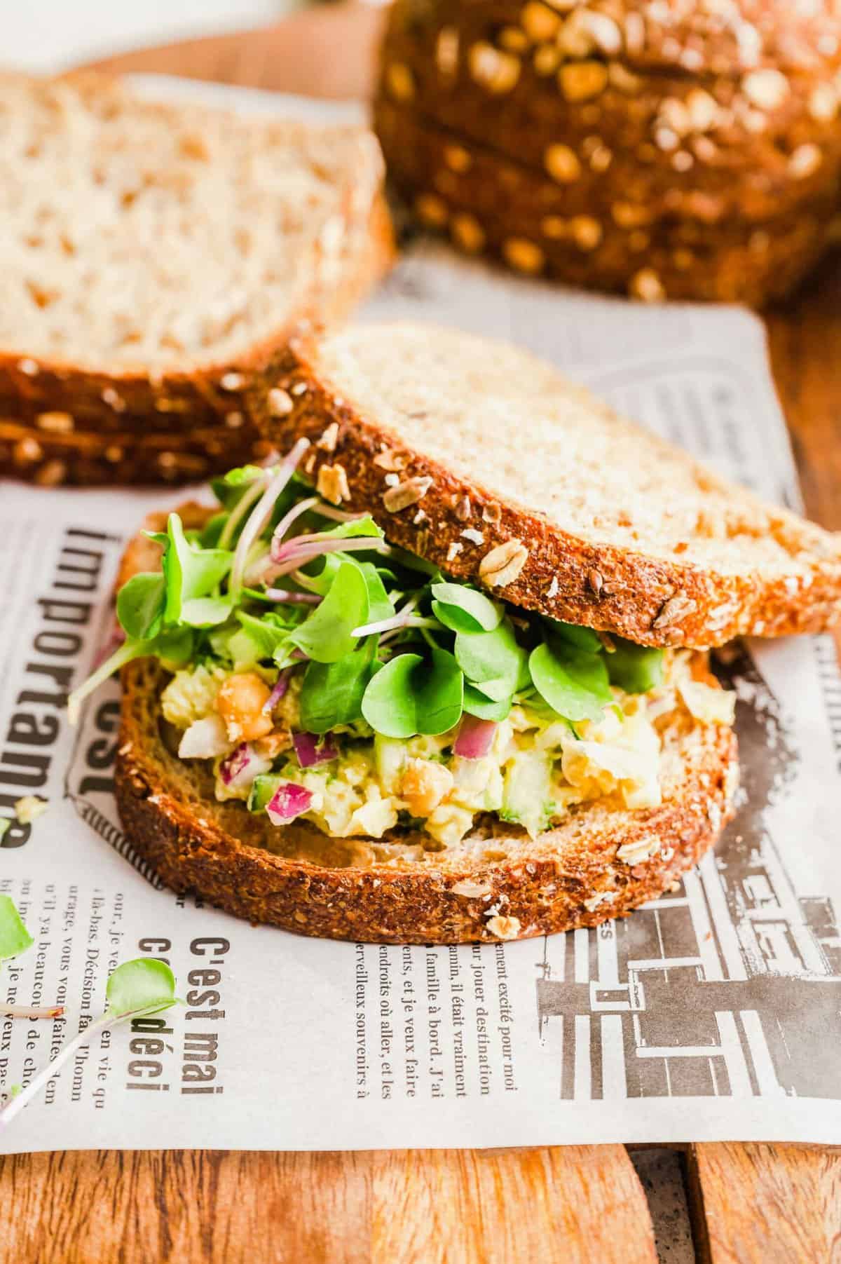 Smashed chickpea sandwich, with slices of bread in background