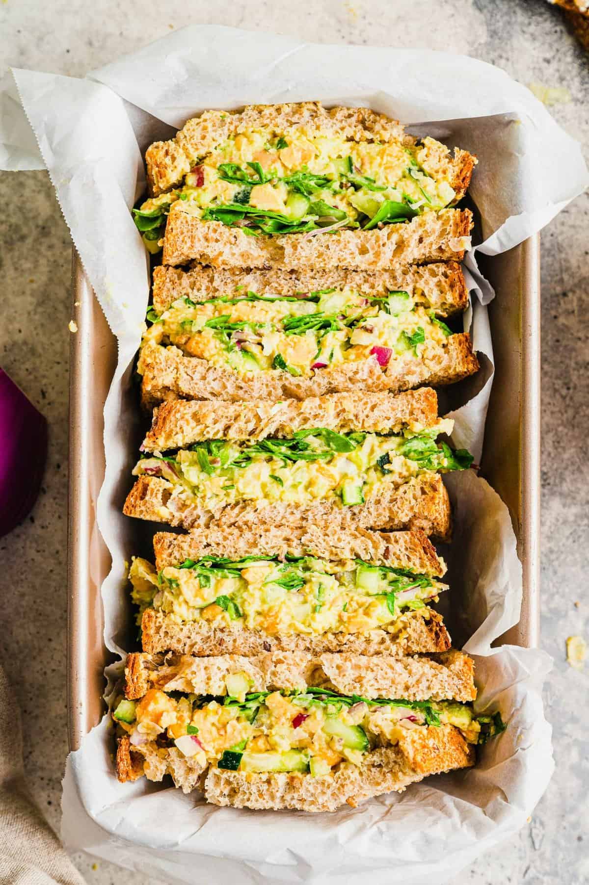 5 halved smashed chickpea sandwiches arranged in loaf pan