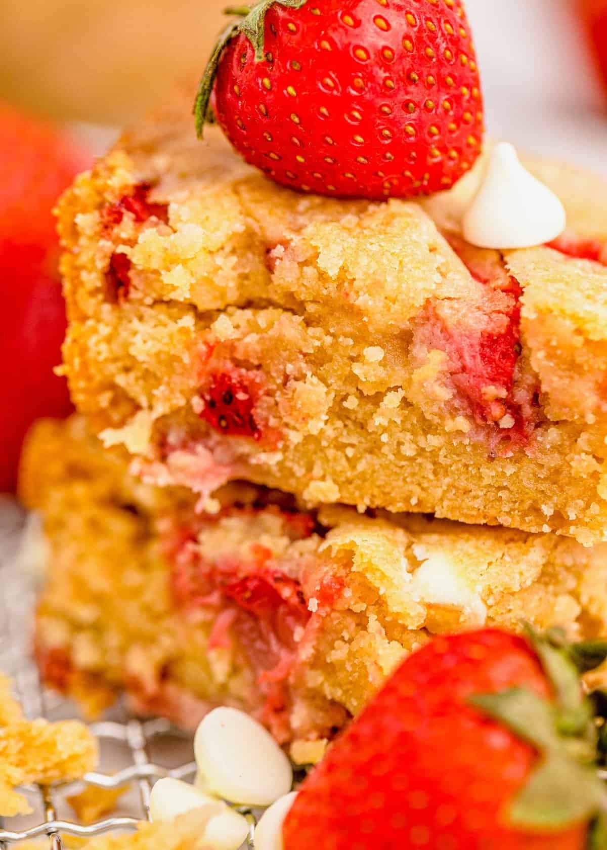 Two strawberry blondies stacked and topped with a fresh strawberry